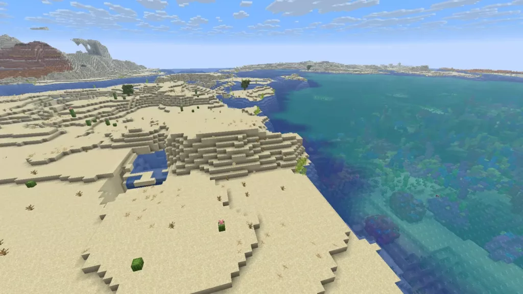 Desert shoreline meets a huge Coral Reef in a Warm Ocean. Sparse life on land, vibrant life underwater.